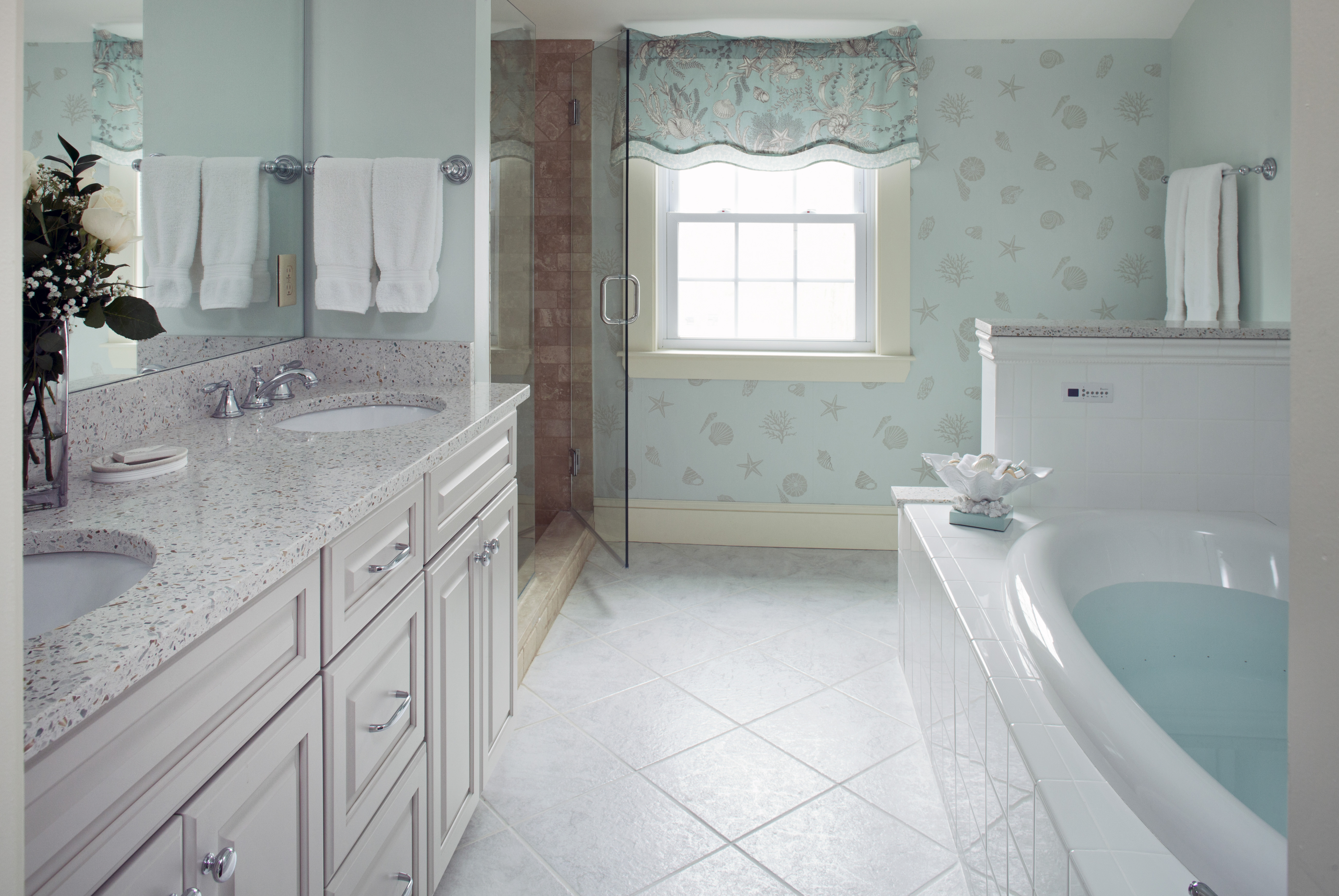 A spacious and elegant bathroom with a double vanity, walk-in shower, and a large soaking tub.