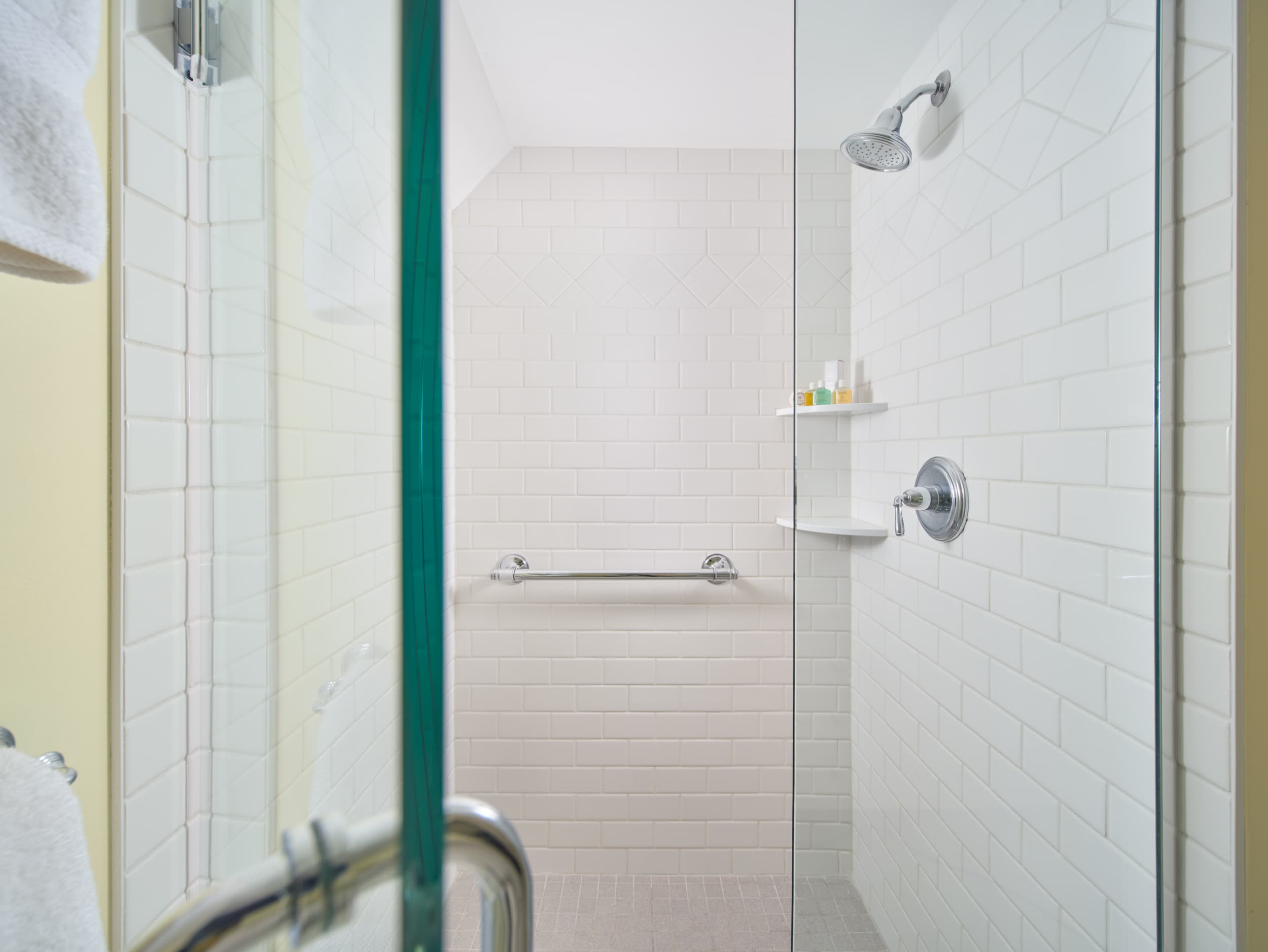 Glass enclosed shower with white tile