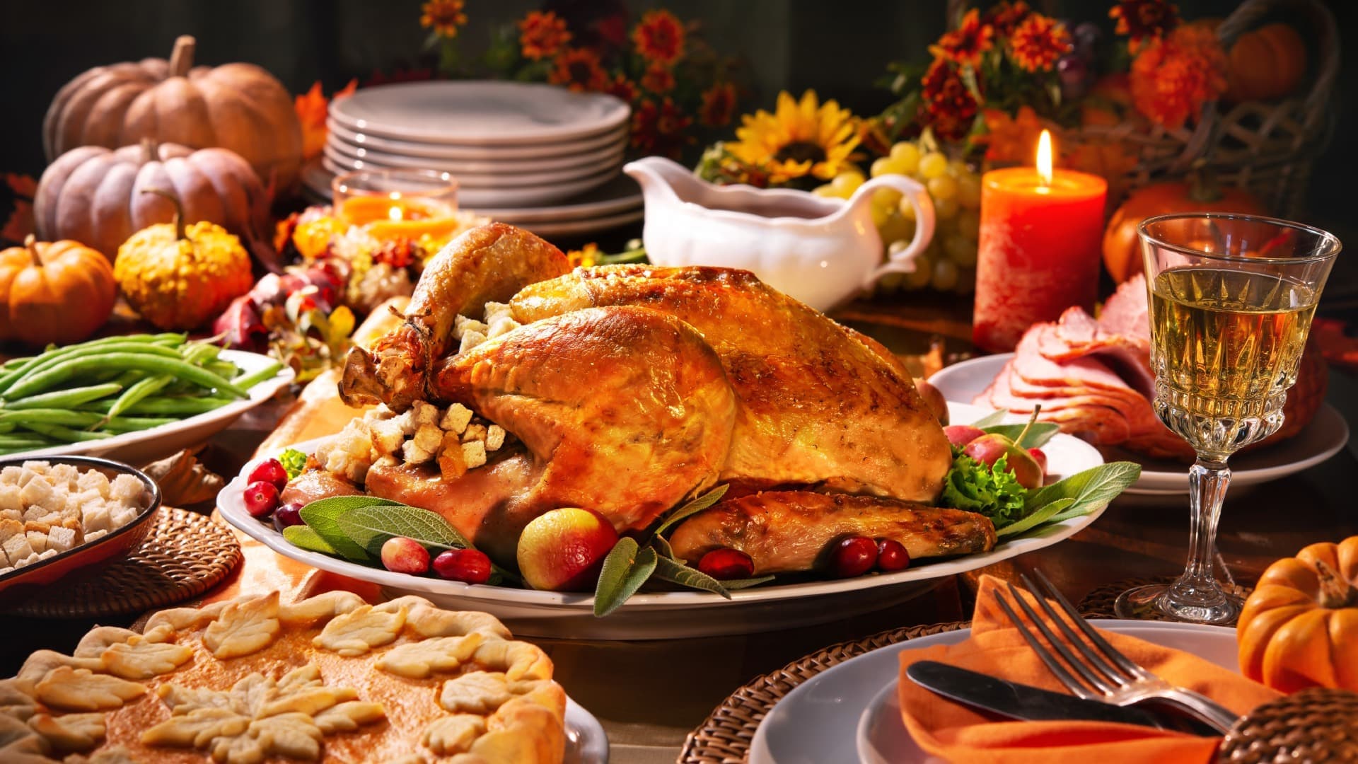 A beautifully arranged Thanksgiving feast featuring a roasted turkey, side dishes, and autumn decorations.