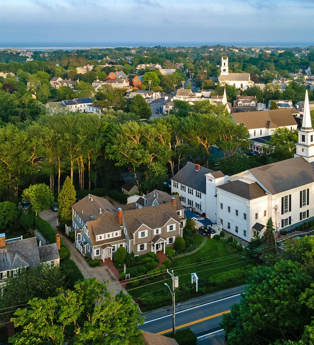 Aerial view of a picturesque town surrounded by greenery and historic buildings.