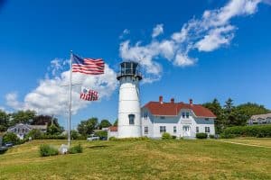 The lighthouse of Chatham and the american flag waving