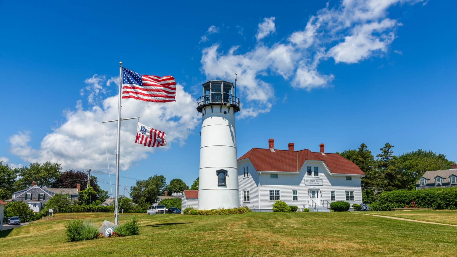 The lighthouse of Chatham and the american flag waving