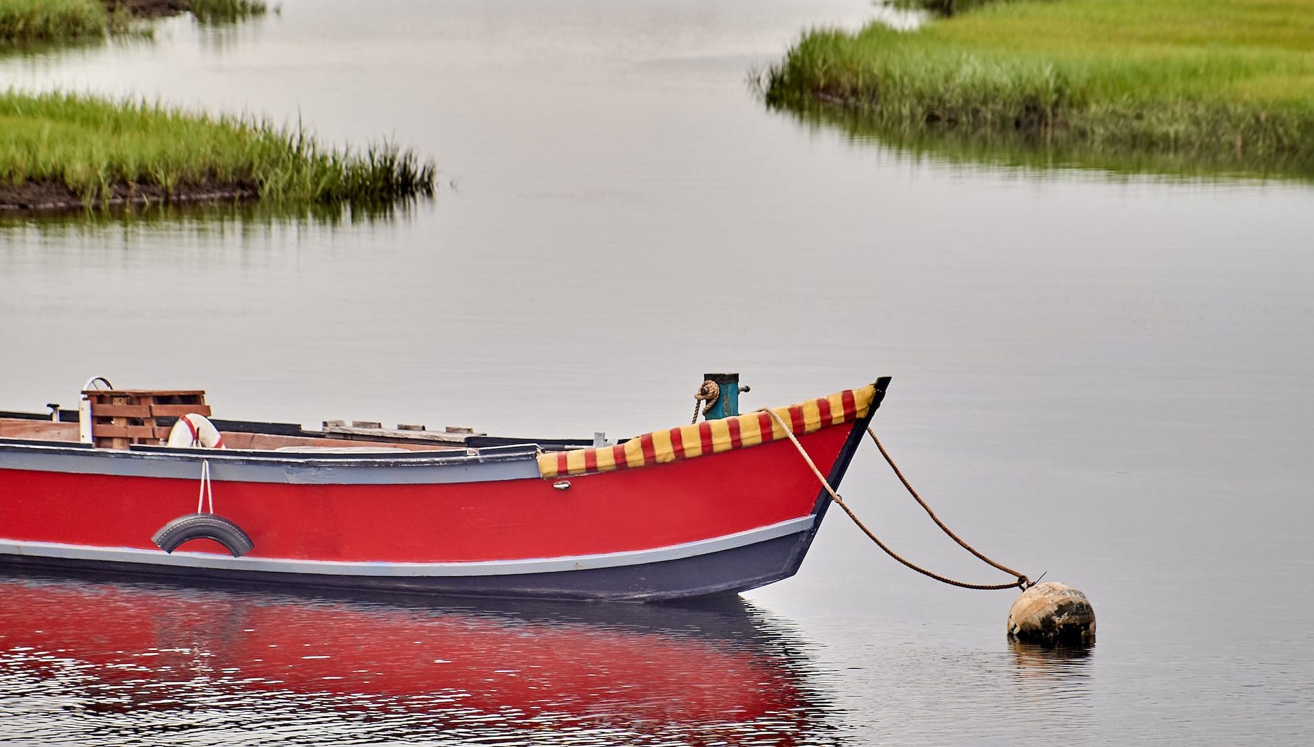 Small red wooden boat moored in Cape Cod, Massachusetts