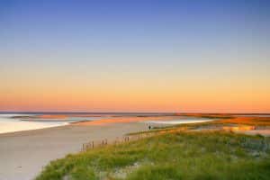 sunset at the beach on Cape Cod is an arm-shaped peninsula nearly coextensive with Barnstable County, Massachusetts[1] and forming the easternmost portion of the state of Massachusetts, in the Northeastern United States. The Cape's small town character and beachfront brings heavy tourism during the summer months.