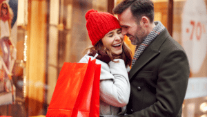 A young couple Christmas shopping & laughing  