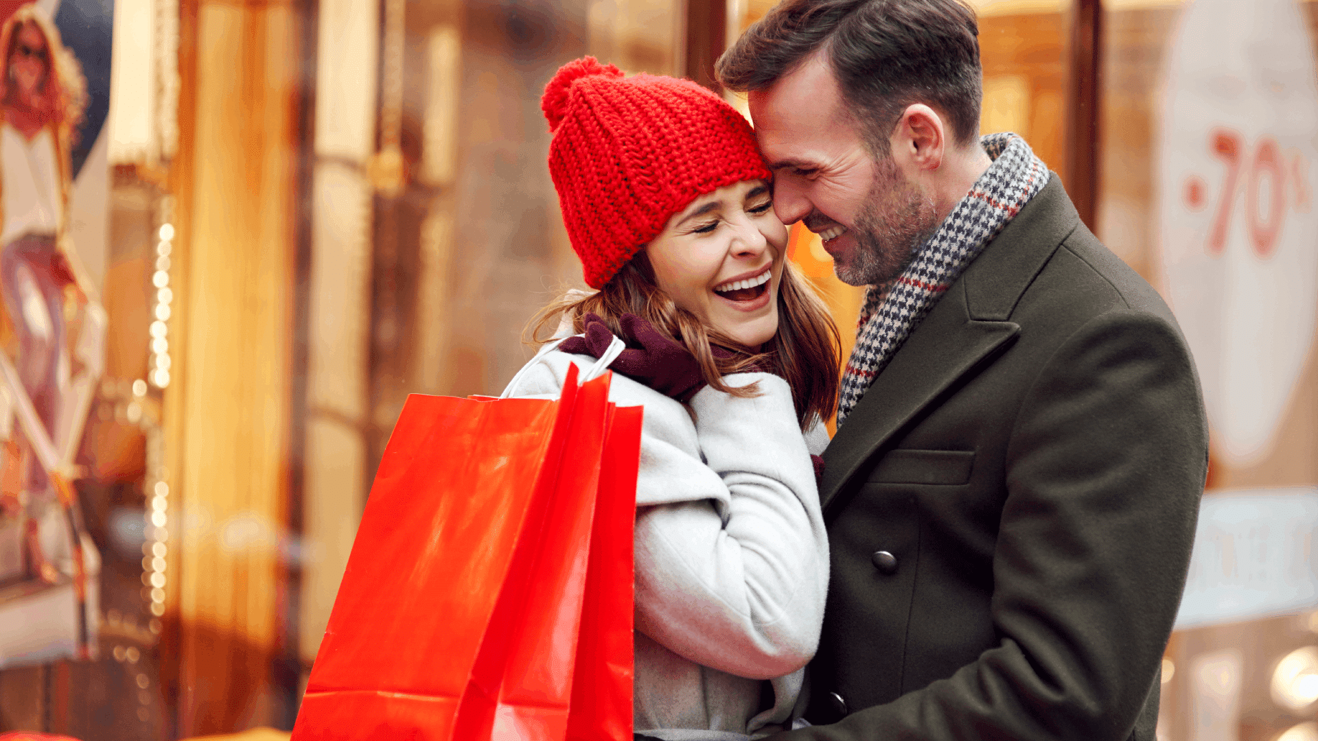 A young couple Christmas shopping & laughing