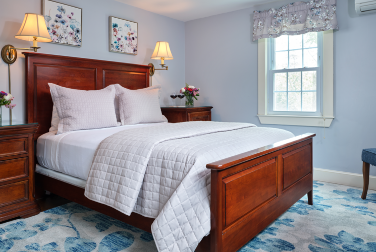 A guest room with a wooden Queen Size bed and two bedside tables