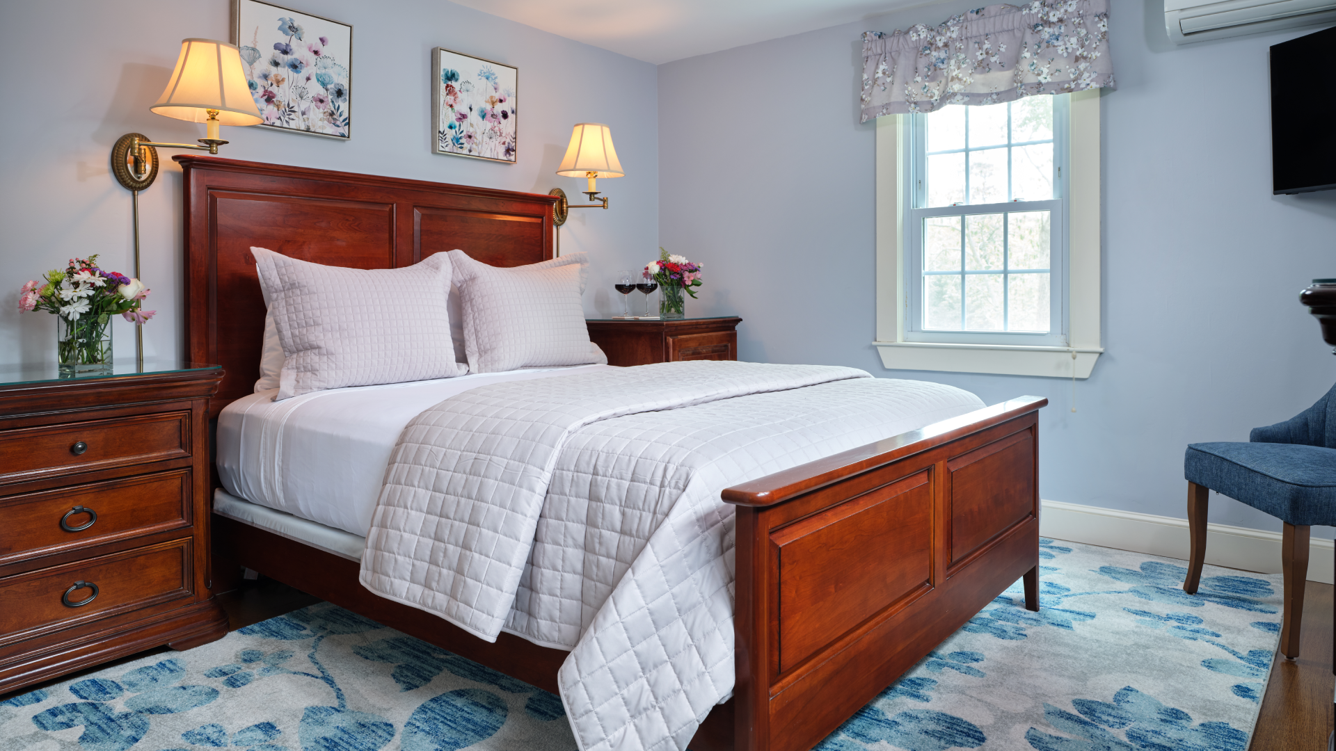 A guest room with a wooden Queen Size bed and two bedside tables