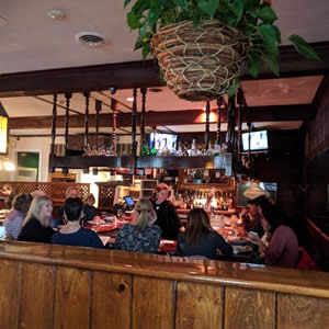 Diners sitting at tables at a wood paneled oyster bar