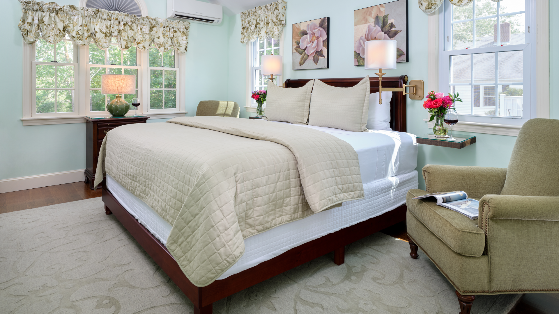 Bedroom with king bed decorated in green, one green reading chair and green rug