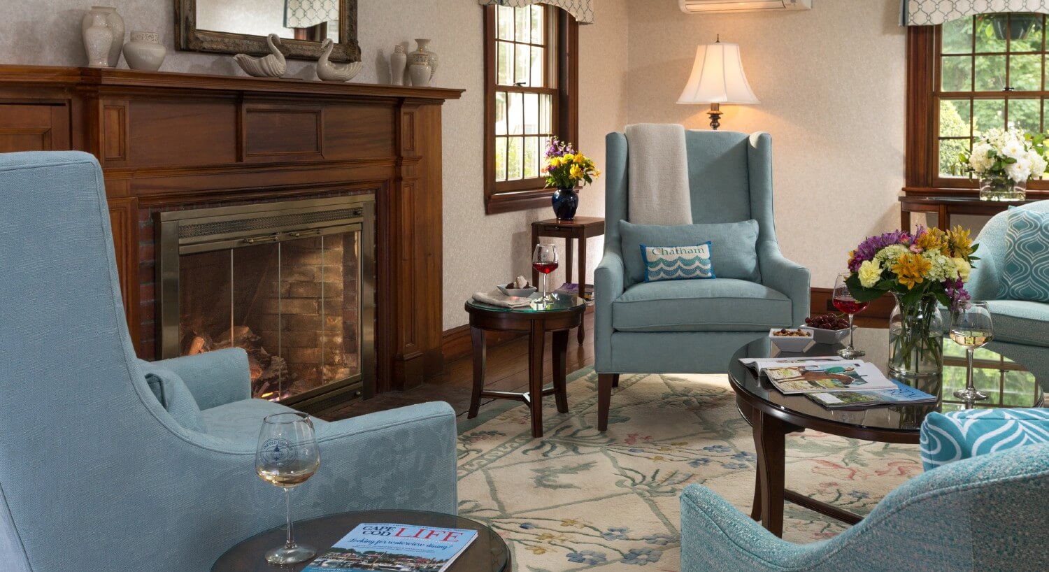 Living room with four blue sitting chairs and coffee table in front of a fireplace