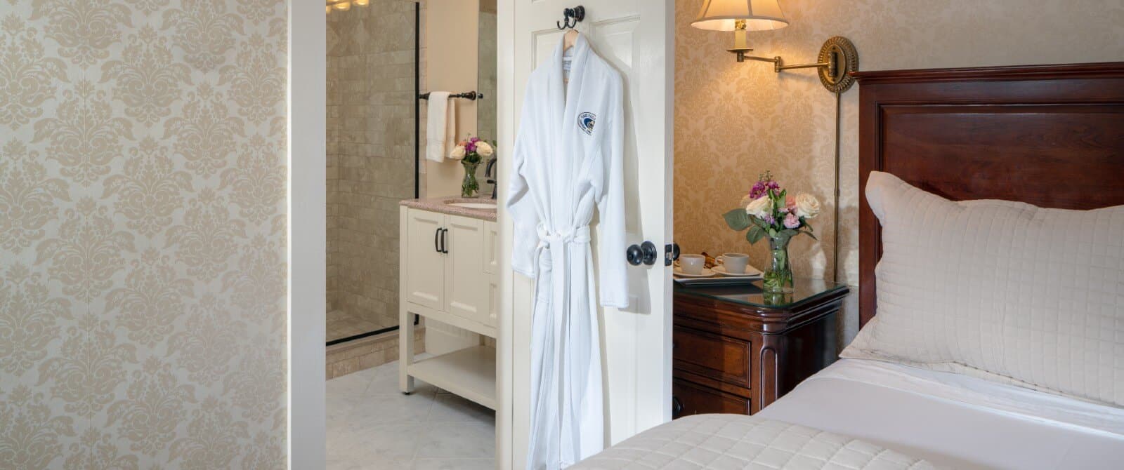 Bedroom with king bed and doorway with white hanging robe open to bathroom