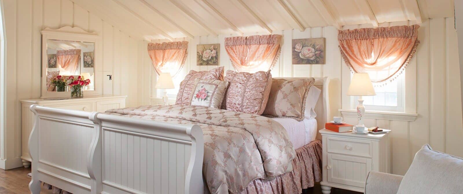 Quaint bedroom with white sleigh bed, shiplap walls and ceilings and dresser with mirror