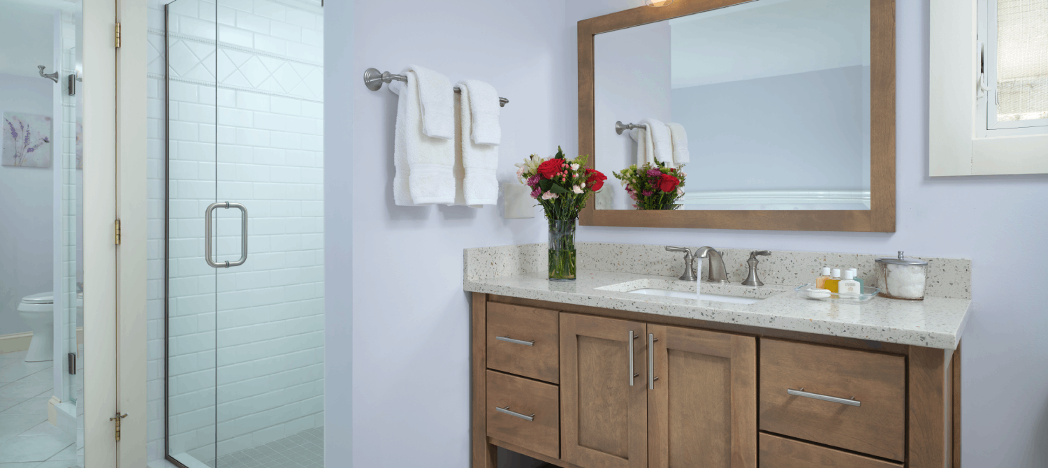 Interior photo of a luxurious bathroom with custom glass inclosed shower and wooden vanity