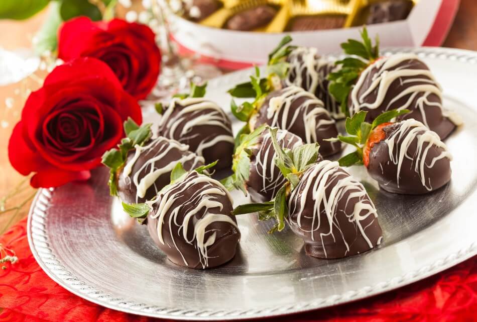 Silver platter with chocolate covered strawberries and a red rose